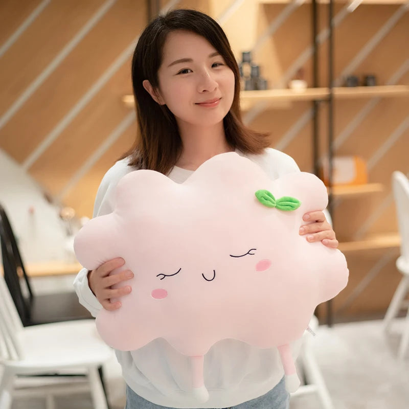 Plush flower and heart-shaped pillows arranged on a pastel bed setup