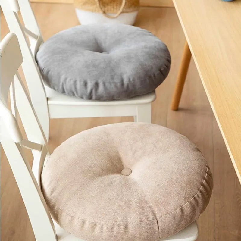 Neutral-colored floor seat cushion placed on a rug in a minimalist room setting