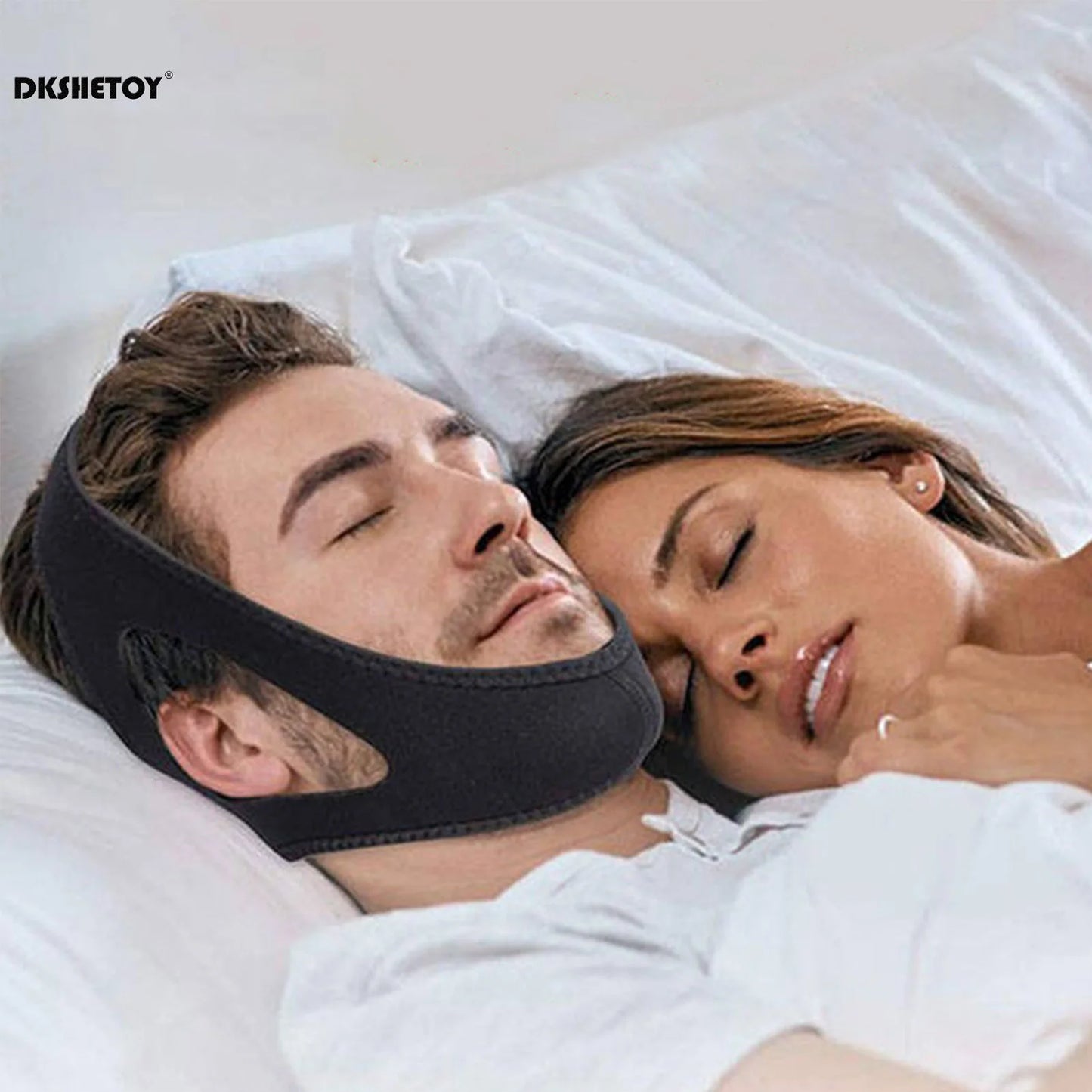 Person wearing anti-snoring chin strap while lying in bed, shown from the side