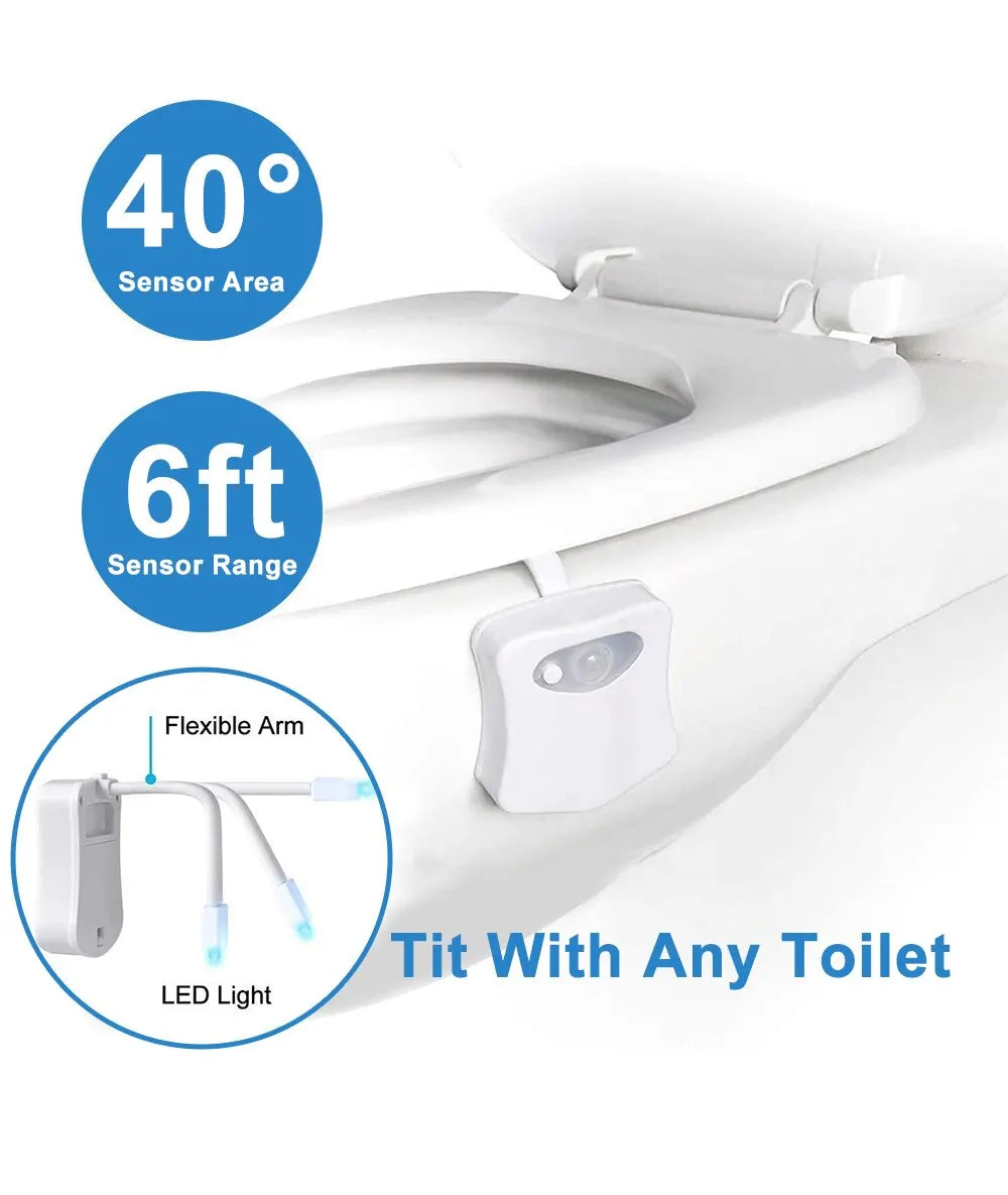 LED toilet night light glowing in soft colors attached to toilet bowl in a dark bathroom