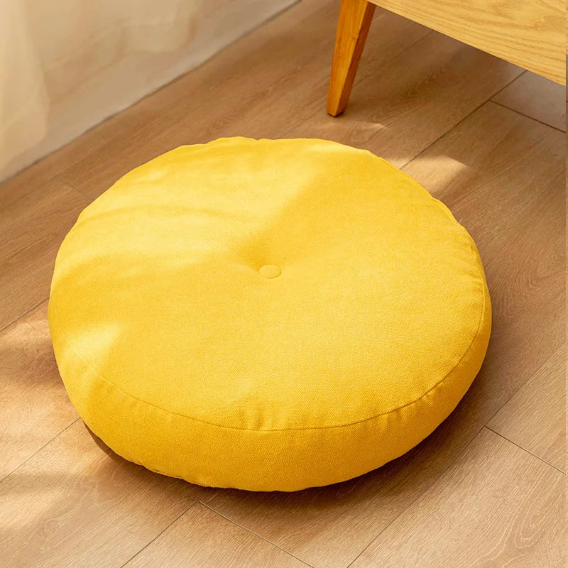 Neutral-colored floor seat cushion placed on a rug in a minimalist room setting