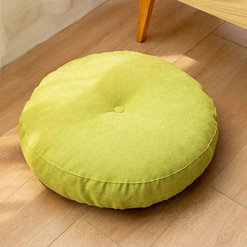 Neutral-colored floor seat cushion placed on a rug in a minimalist room setting