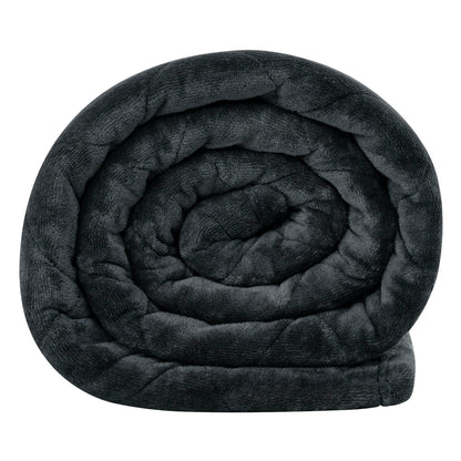 Weighted blanket draped over a bed with soft lighting, creating a cozy and calming atmosphere
