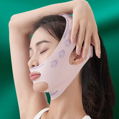 Model wearing a 3D V-line slimming mask that wraps around chin and jaw, in a soft lighting setup
