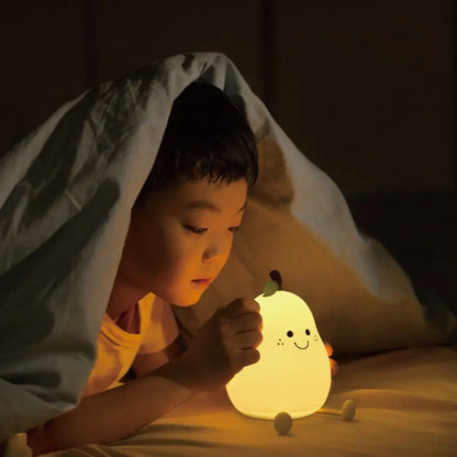 Pear-shaped silicone night light glowing softly on a bedside table in a child’s room
