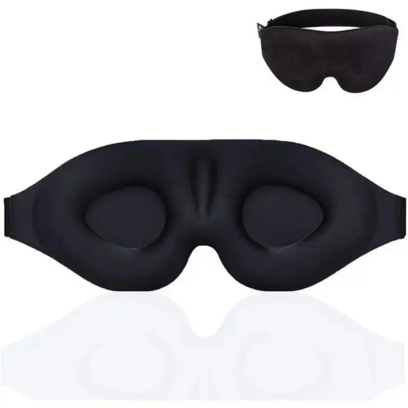 3D contoured sleep mask resting on a pillow, showing raised eye cups and soft material
