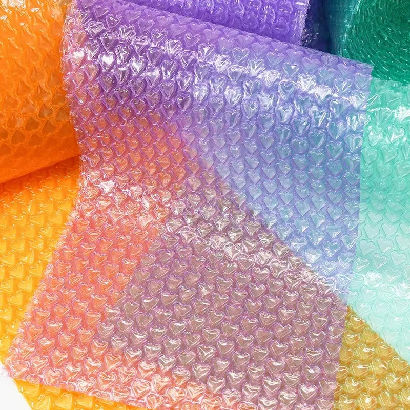 Hands popping bubble paper roll laid out on a desk in a relaxed workspace
