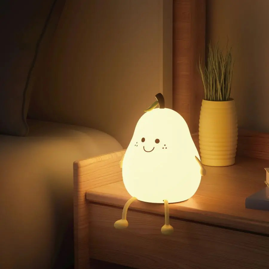 Pear-shaped silicone night light glowing softly on a bedside table in a child’s room
