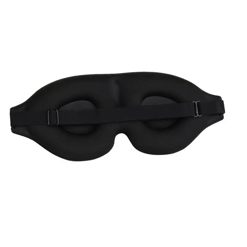 3D contoured sleep mask resting on a pillow, showing raised eye cups and soft material
