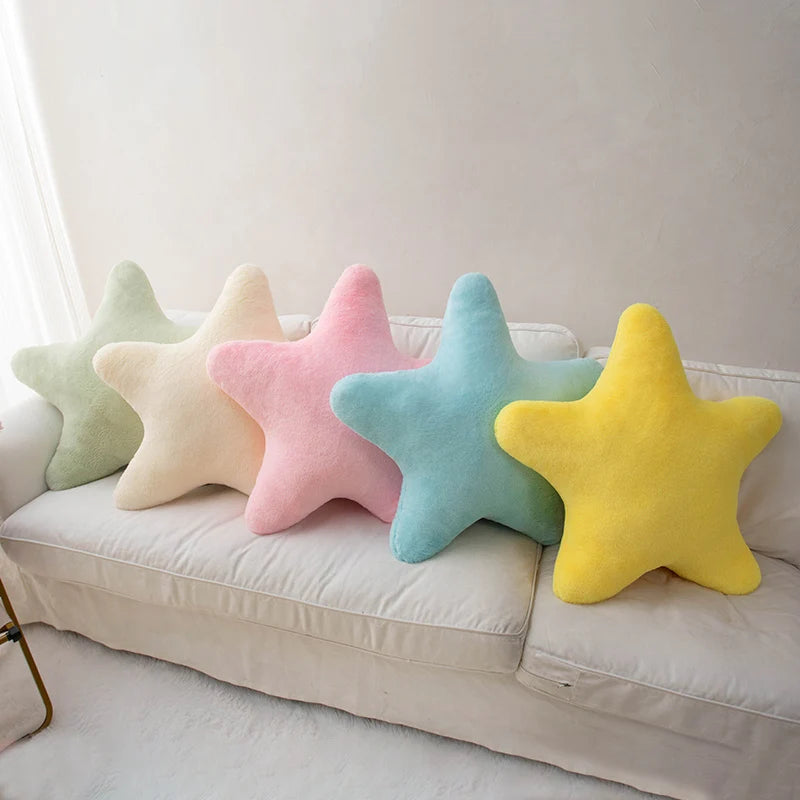 Soft star-shaped plush pillow in pastel color resting on a cozy bed or sofa
