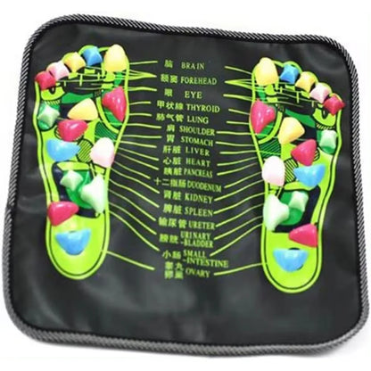 Foot massage pad with acupressure points placed on the floor, with bare feet standing on it
